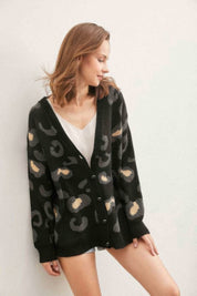 A woman wearing a black leopard print cardigan