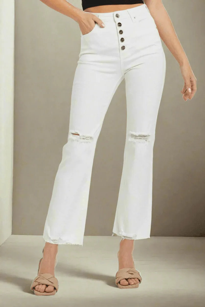 A woman wearing a pair of white distressed denim button fly straight crop deim jeans