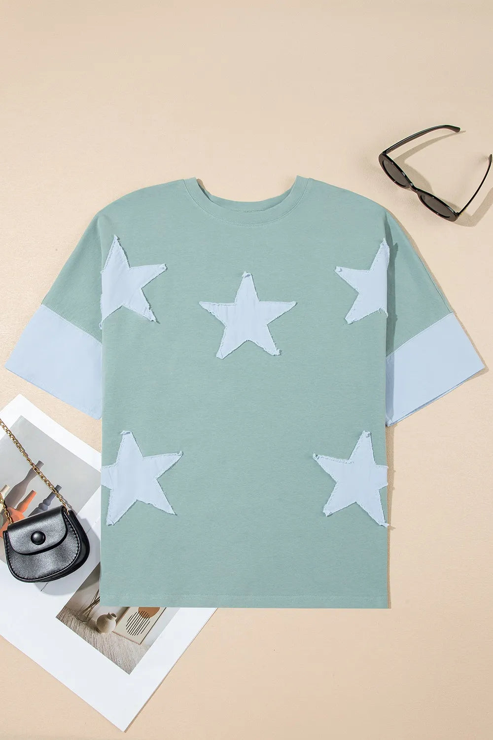 Mint green star-patterned oversize t-shirt with frayed denim patches and light blue cuffs