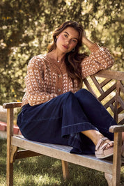 Brown and white SO ME cable knit sweater cardigan with navy corduroy pants and tan sandals