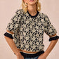 Black and cream floral BiBi rose knit top with ruffled puff sleeves