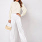 Cream-colored structured shoulder bag with chain strap in Ruched Mock Neck Blouse