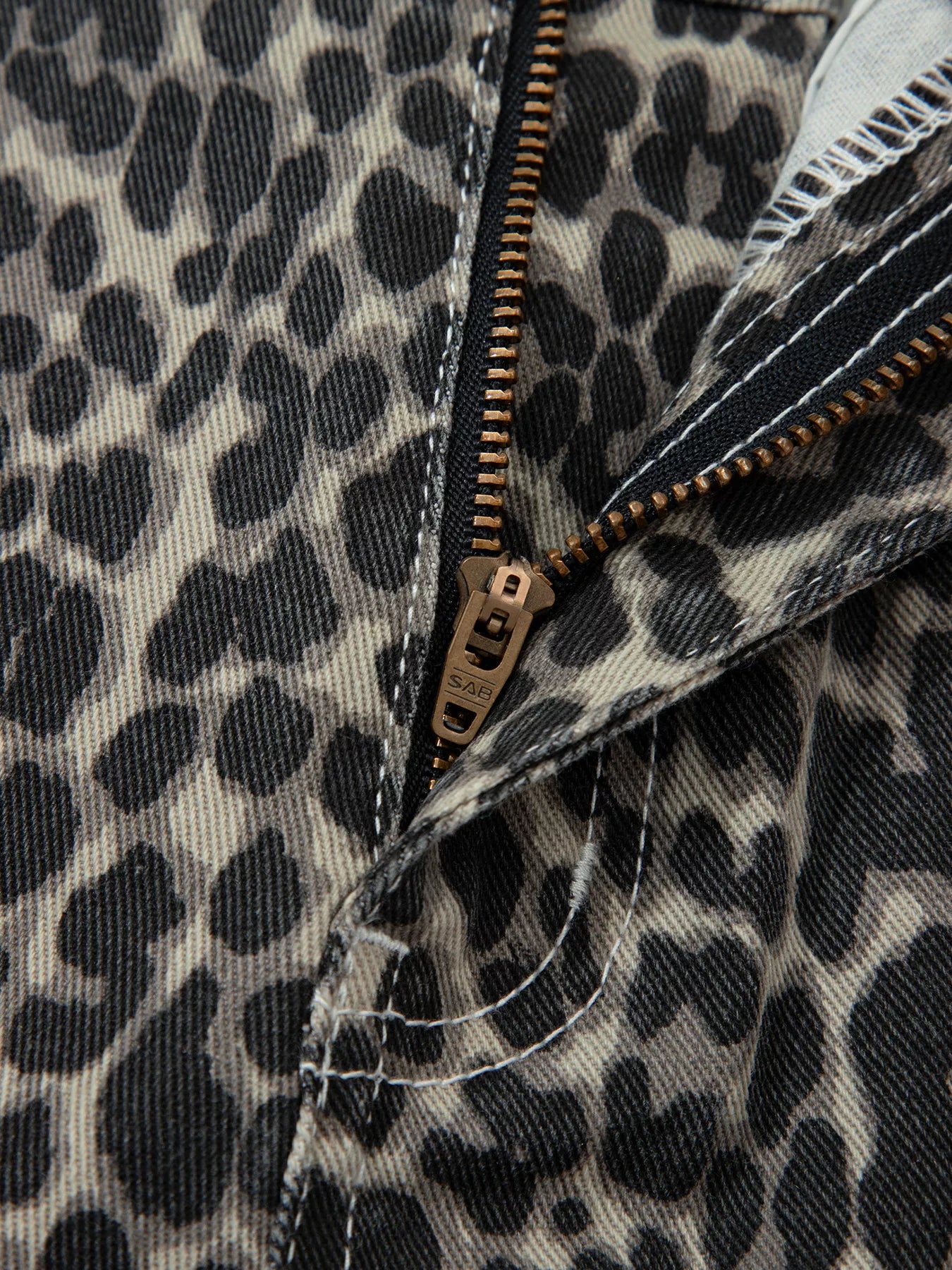 Leopard-print denim jacket with brass zipper and frayed hem on Daverri jeans