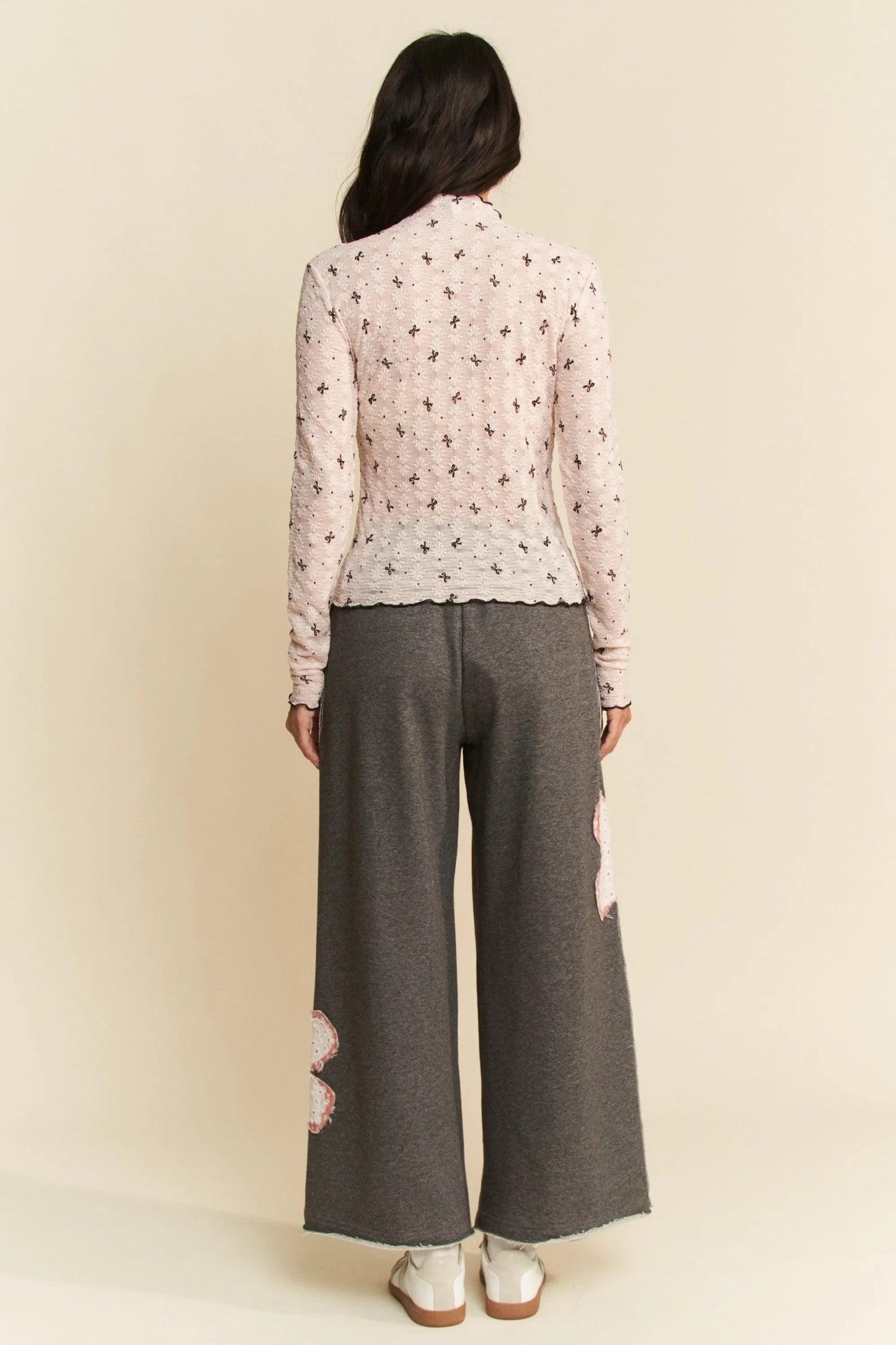 Soft pink long-sleeved Davi & Dani blouse with black cross pattern and lace hem