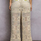 Cream-colored POL openwork crochet flare pants with green floral accents