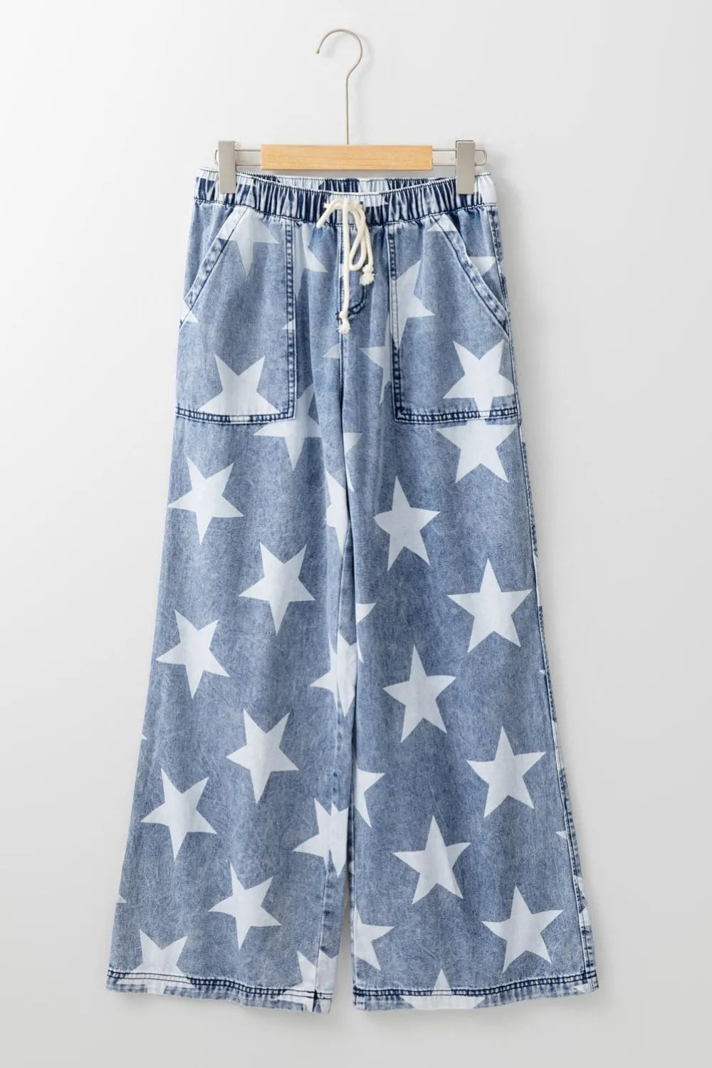 Blue denim wide-leg jeans with white star print and drawstring waist