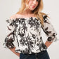White and black floral smocked off-shoulder top with ruffled sleeves