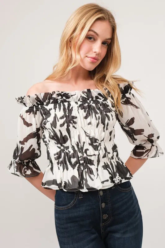 White and black floral smocked off-shoulder top with ruffled sleeves