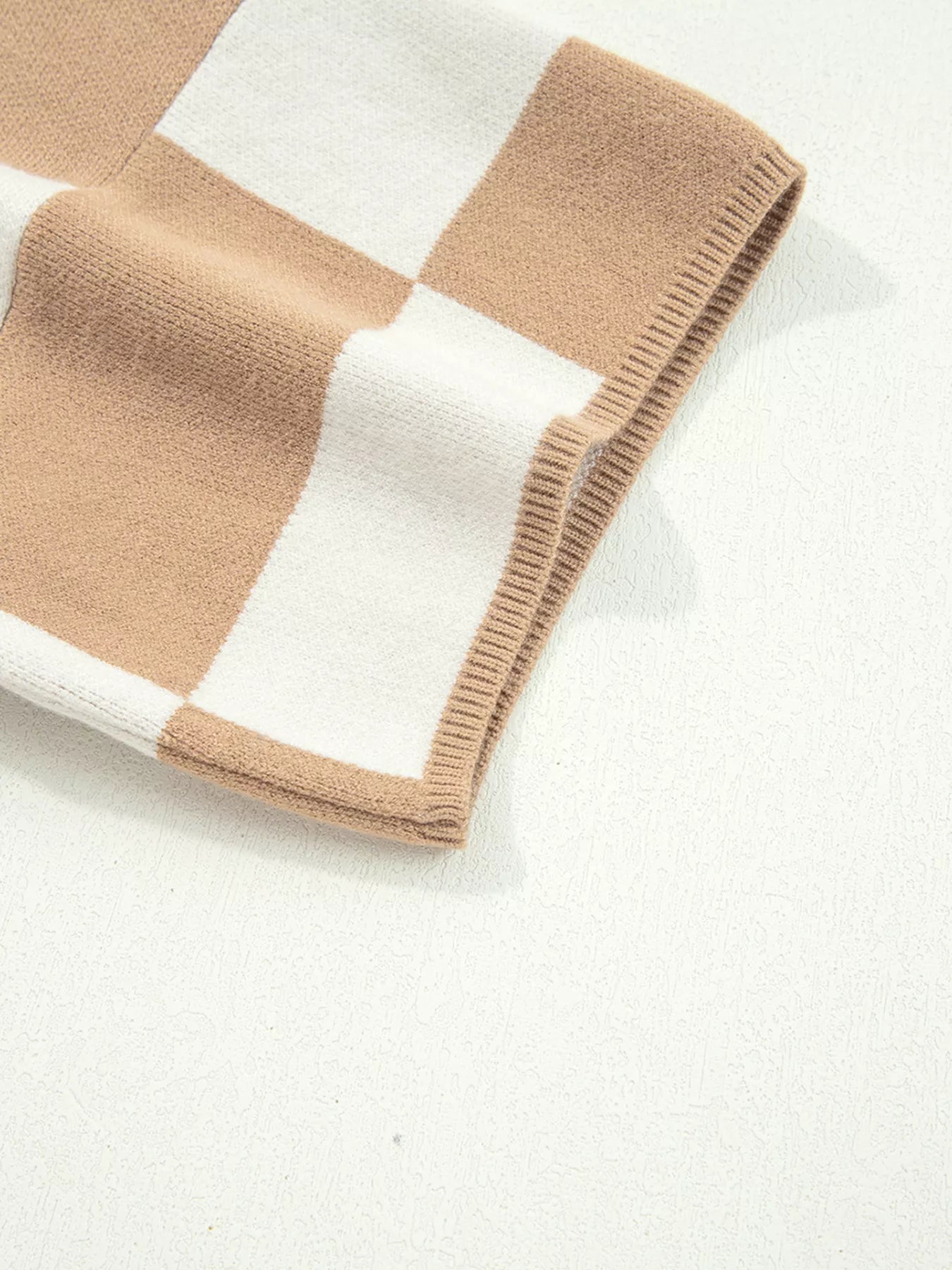 Beige and white checkered knit blanket sweater with ribbed edges