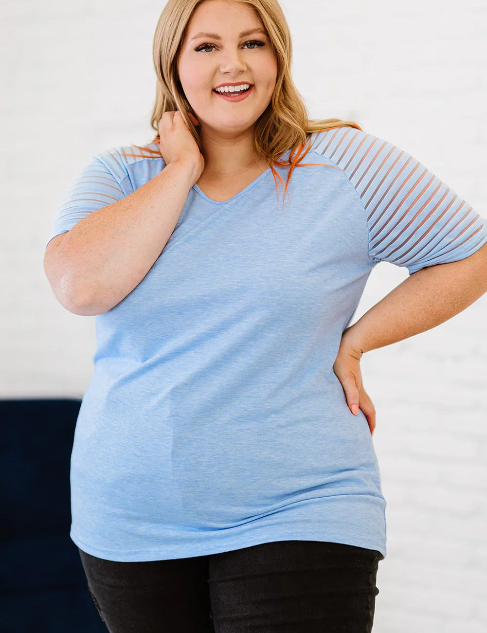 Plus size V-neck raglan tee in light blue with mesh sleeves and black leggings