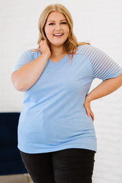 Plus size V-neck raglan tee in light blue with mesh sleeves and black leggings