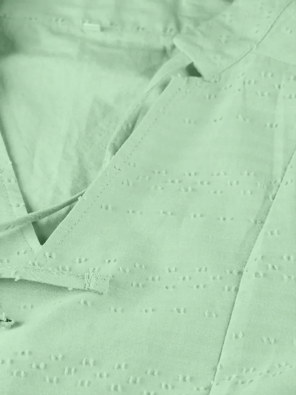 Delicate mint-green eyelet blouse detail on full size tied three-quarter sleeve mini dress