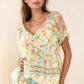 Woman in Davi & Dani Spring Floral Border Print Ruffled Textured Top
