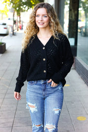 Black sequined pointelle knit button-down cardigan with distressed jeans