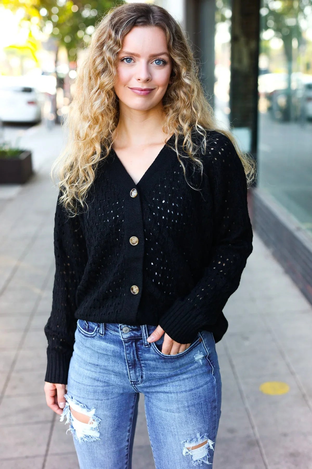 Black pointelle knit button-down cardigan with silver sequins and distressed jeans