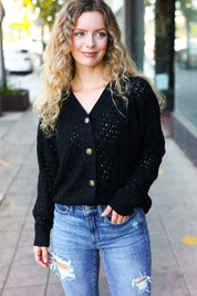 Black sequined Follow Me pointelle knit cardigan with gold buttons and distressed jeans