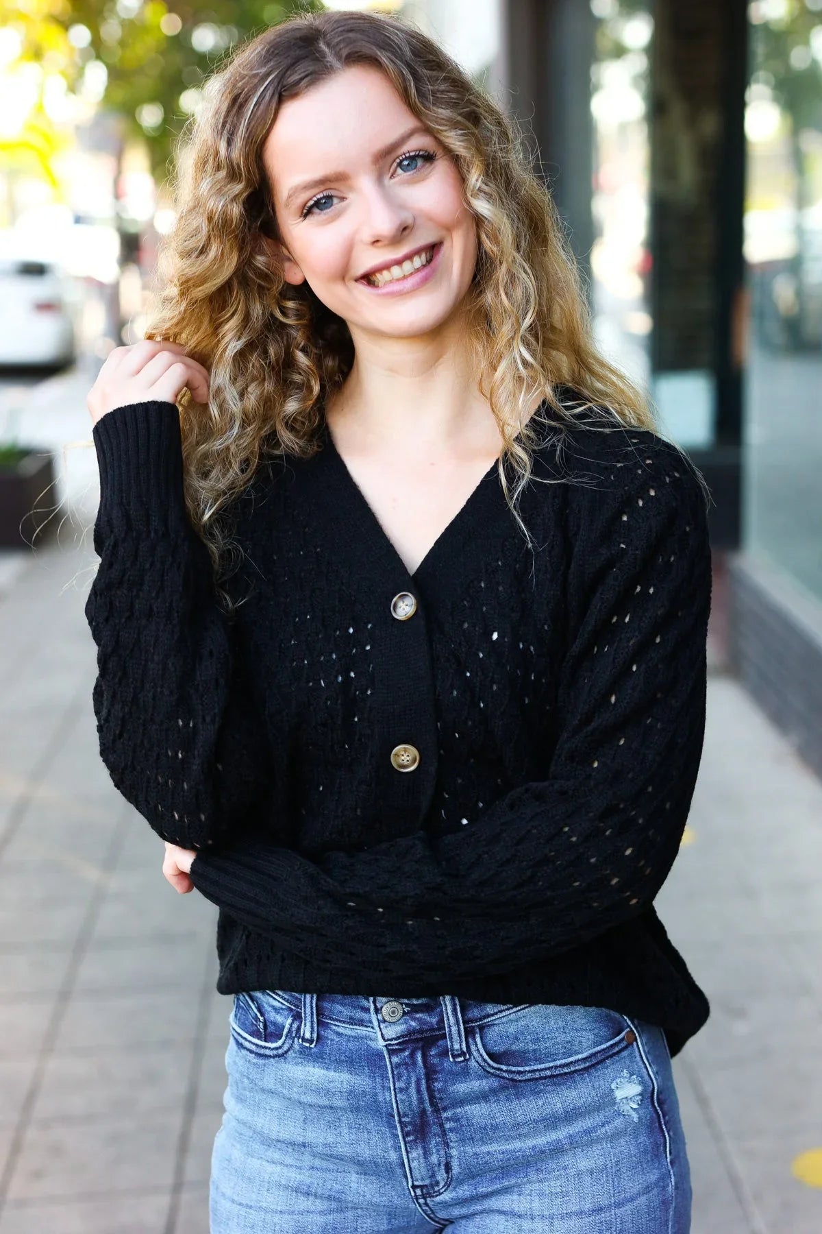 Black cable knit cardigan with gold buttons and speckled texture