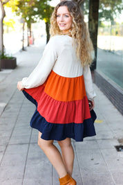 Multicolored tiered babydoll dress with orange, red, navy layers