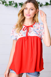 Red and white floral print tie neck dolman top with short sleeves