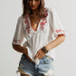 White embroidered floral V-neck blouse with ruffled sleeves
