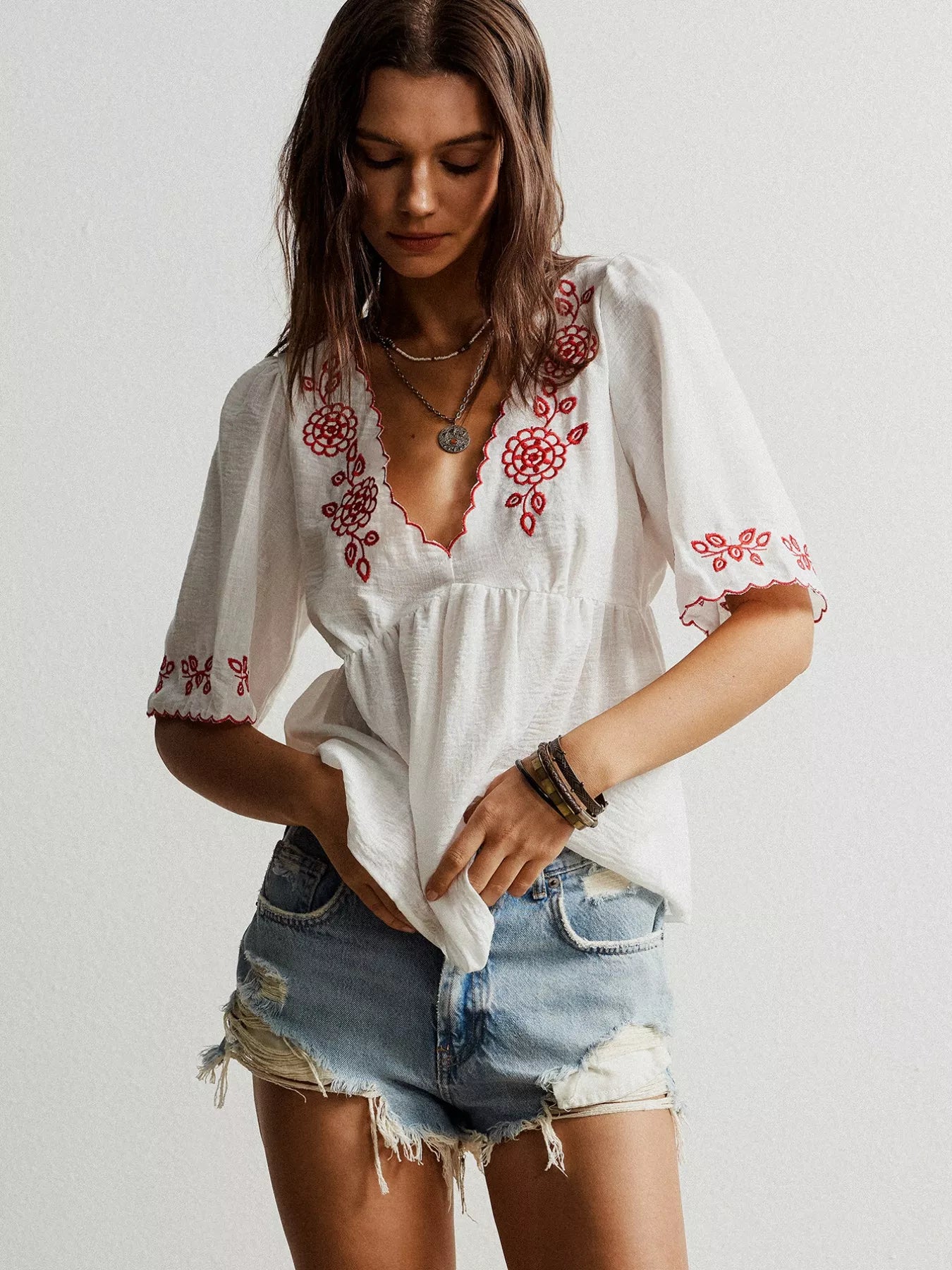 White embroidered floral V-neck blouse with ruffled sleeves