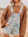 Distressed denim overalls shorts in light-wash with frayed hem