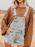 Distressed denim overalls shorts in light-wash with frayed hem