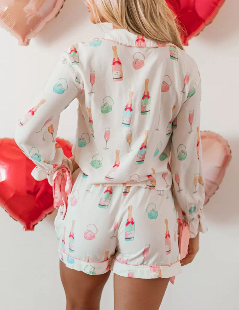 Champagne-themed pink gold pajama set with bow print
