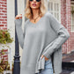 Light gray oversized V-neck sweater with slit exposed seams, ribbed cuffs and hem