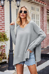Light gray oversized V-neck sweater with slit exposed seams, ribbed cuffs and hem