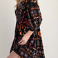 Black bohemian floral print long sleeve mini wrap dress with vibrant orange, red, and purple botanical patterns