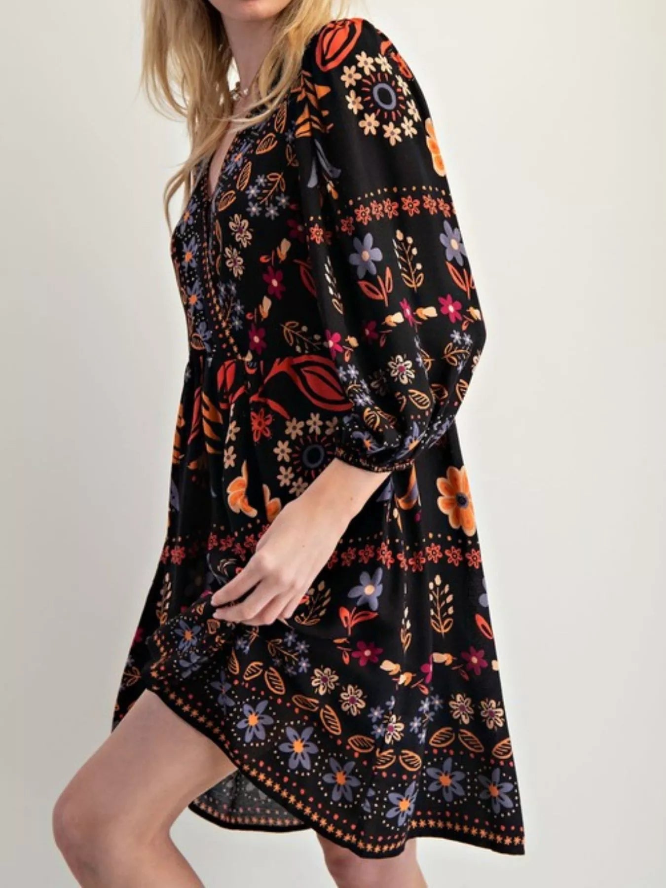 Black bohemian floral print long sleeve mini wrap dress with vibrant orange, red, and purple botanical patterns