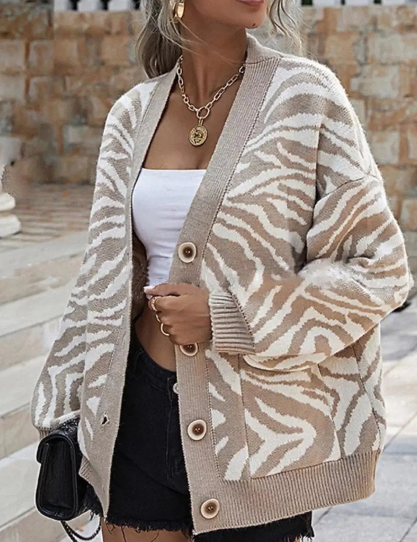 Beige zebra print button-up cardigan with wooden buttons and black trim