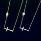 Two necklaces with cross pendants with bezel moissanite stones on a dark background