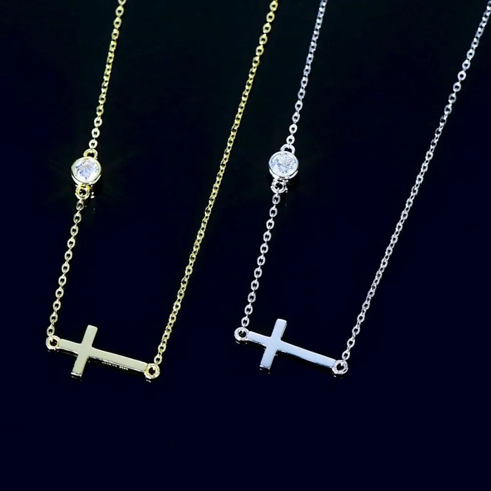 Two necklaces with cross pendants with bezel moissanite stones on a dark background