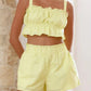 Light yellow ruffled Daverri crop top with thin straps and elastic waistband