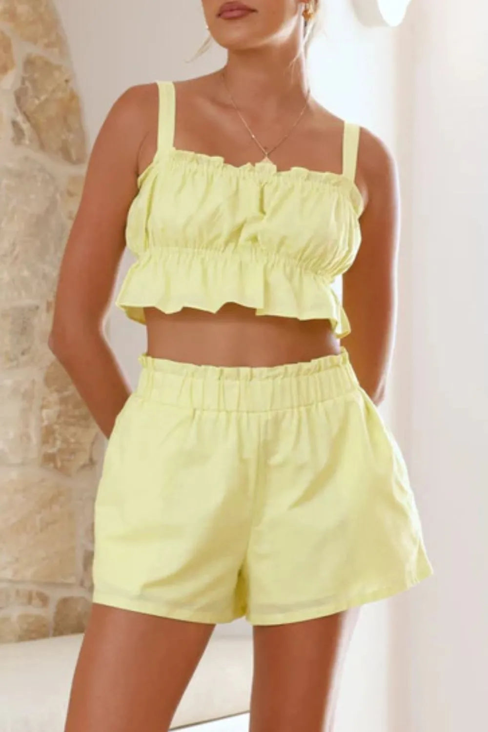 Light yellow ruffled Daverri crop top with thin straps and elastic waistband