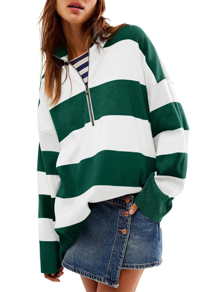 Green and white striped sweater worn by a person on a white background