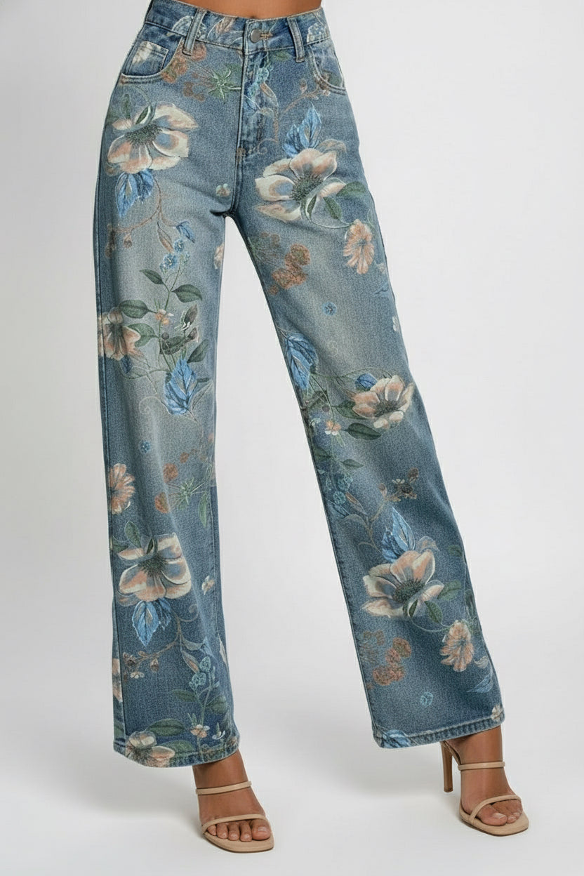 Person wearing floral-patterned jeans in a room with a window and shelves.