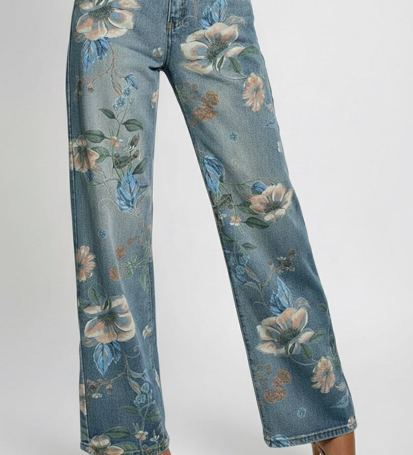 Person wearing floral-patterned jeans in a room with a window and shelves.