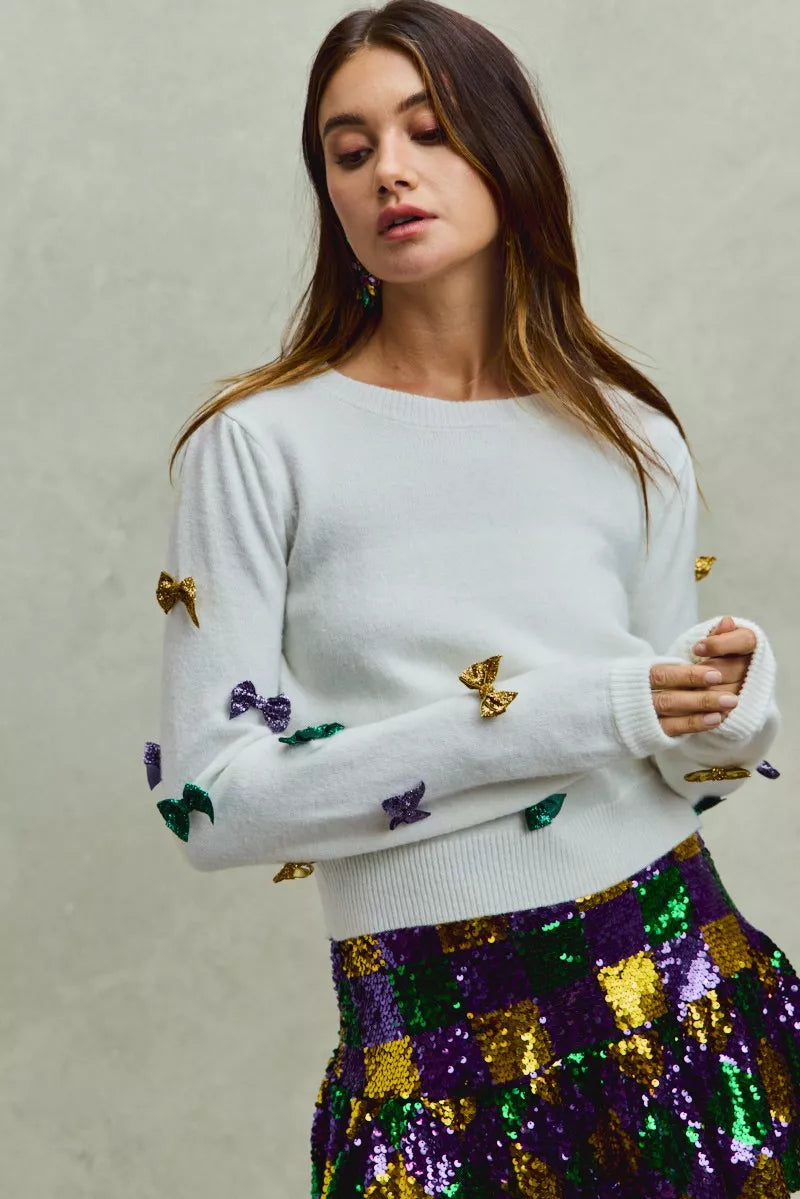 White SO ME Mardi Gras glitter bow knit sweater with gold purple sequins
