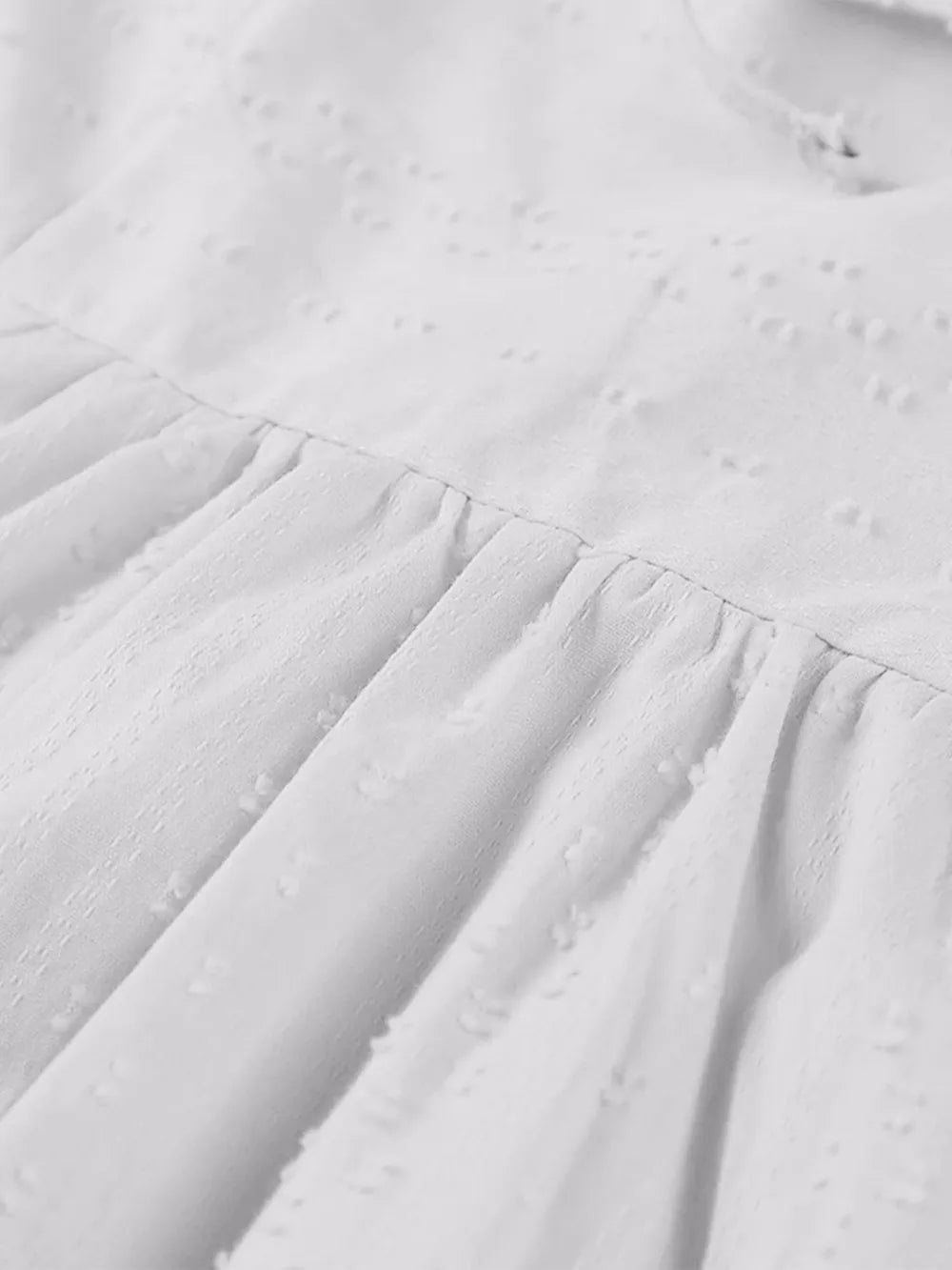 White eyelet mini dress with pleats, ties and 3/4 sleeves, full size view