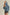 Woman wearing a blue denim jacket against a beige background