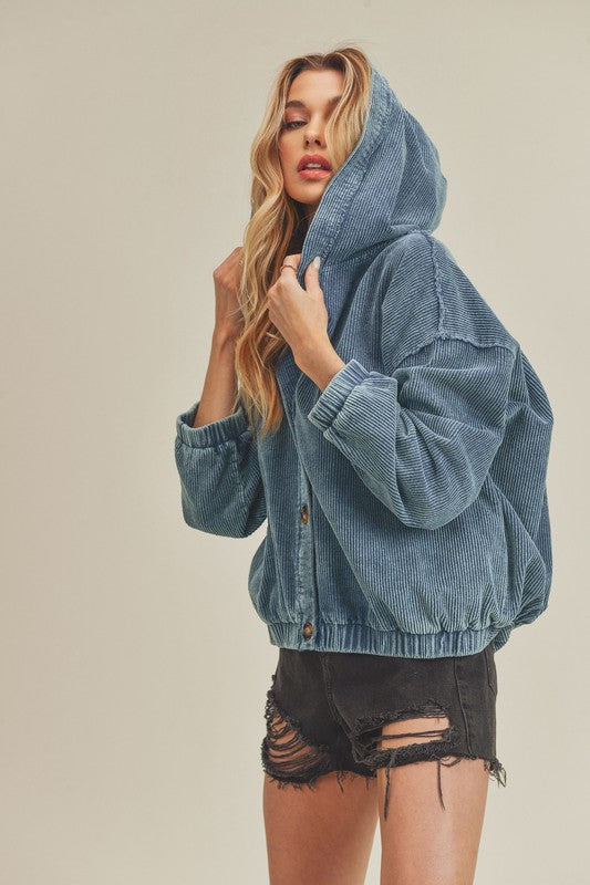Woman wearing a blue denim jacket against a beige background