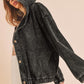Black corduroy jacket worn by a person on a beige background