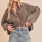 Woman wearing a brown corduroy jacket and denim shorts on a beige background