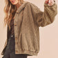 Woman wearing a brown corduroy jacket on a beige background