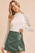 Green faux leather wrap skirt with Aemi + Co mock neck lace top