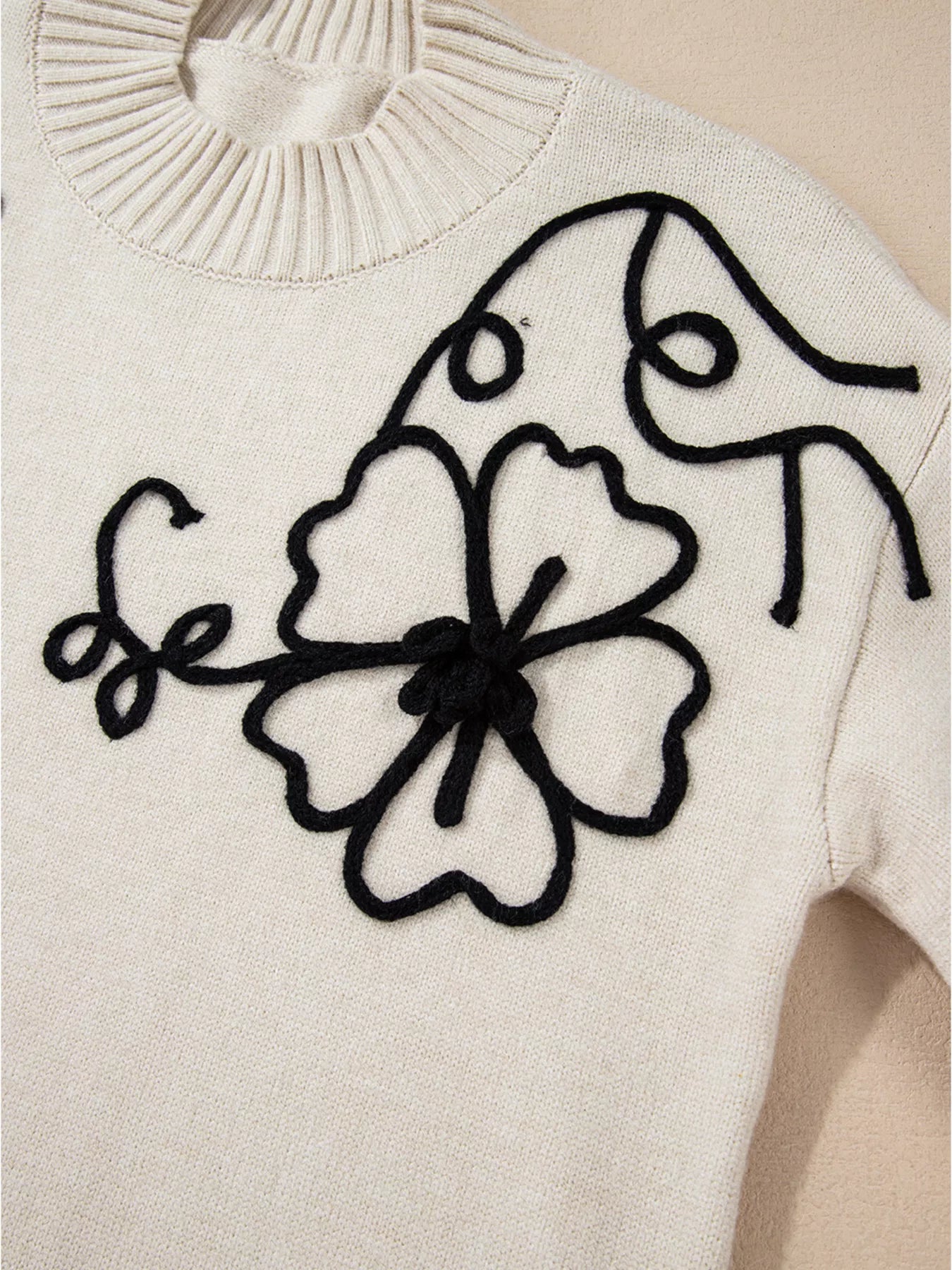 Flower Stitching Mock Neck Sweater in white with black floral embroidery