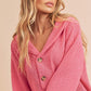Pink textured knit V-neck hoodie with wooden buttons by Aemi + Co